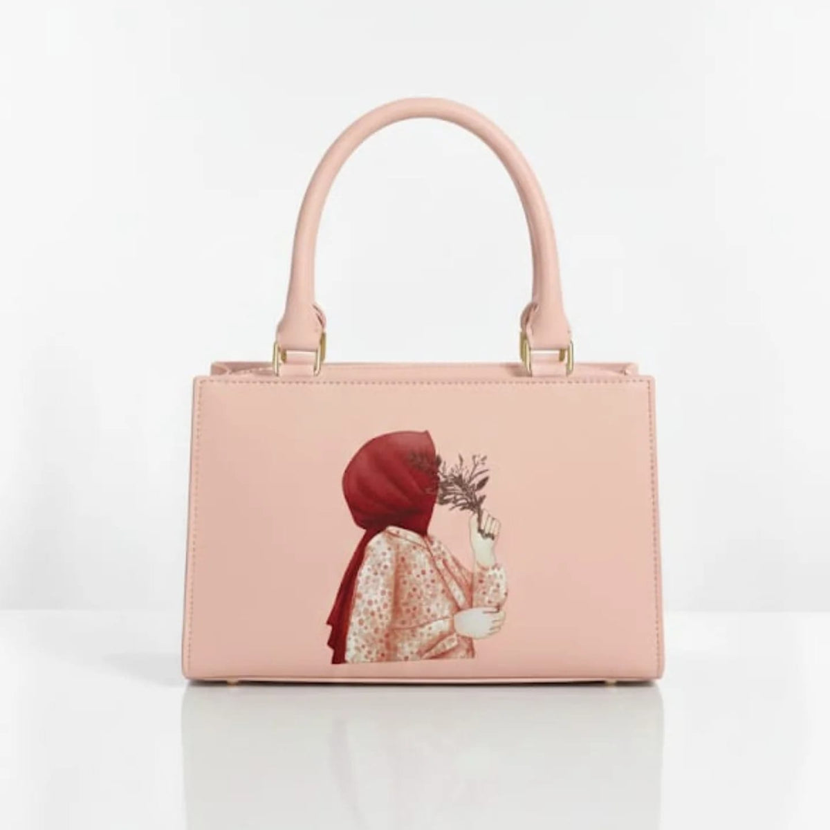 Blush pink top-handle handbag with floral illustration and gold-tone hardware